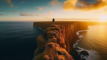 Mann Stehen auf oben von Cliff beim Sonnenuntergang , zurück Aussicht oder Nein Gesicht generativ ai foto