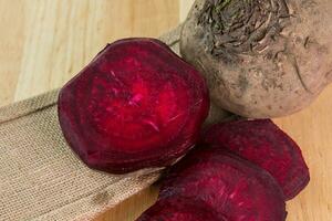 Rote Beete auf Sackleinen und hölzern Schreibtisch foto