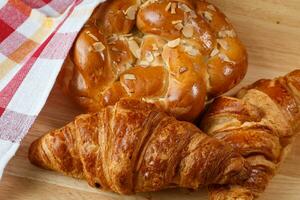 lecker Croissants und Gebäck auf hölzern Hintergrund foto