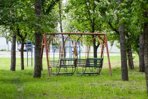 schwingen im das Park. Spielplatz zum Kinder- Spiele im das Park. schwingen runden. foto