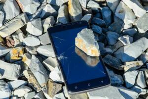 frustriert Telefon auf das Felsen. Glas zerschlagen auf Felsen auf ein sma foto