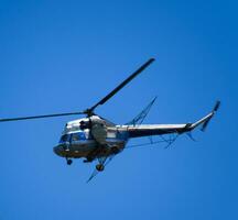 ein Hubschrauber von landwirtschaftlich Luftfahrt ist fliegend im das Blau Himmel. foto