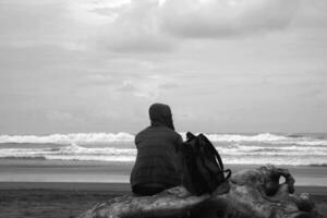 ein Mann sitzt auf das Strand foto