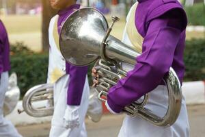 Studenten tragen Mellophone im das Schule Orchester Prozession es ist ein mittlere Tonhöhe Messing- Instrument benutzt im marschieren Bands und ist benutzt zu abspielen das Französisch Horn Sektion im Bands und Orchester. foto