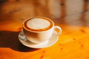 Kaffee im Weiß Tasse auf hölzern Tisch, mit Löffel. foto