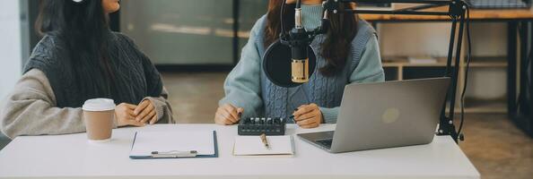 frau, die einen podcast auf ihrem laptop mit kopfhörern und einem mikroskop aufnimmt. weiblicher podcaster, der audio-podcast von ihrem heimstudio macht. foto