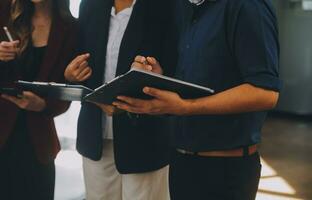 gruppe junger asiatischer geschäftsteams kreative geschäftsleute mitarbeiter im büro glücklich über erfolgreiche partnerschaft teamarbeit zur feier von leistung und erfolgskonzept. foto