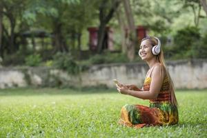 asiatische Frau hört Lieblingsmusik über Kopfhörer. glückliche Zeit und entspannen. foto