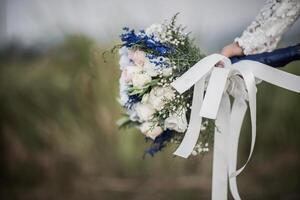 Brauthand, die Blume am Hochzeitstag hält foto