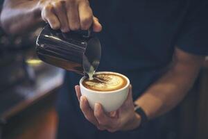 Nahaufnahme der Hände Barista machen Latte Coffee Art Paint foto