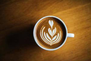 Latte Art in Kaffeetasse auf dem Cafétisch