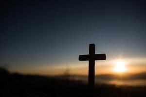 Silhouette des katholischen Kreuzes und des Sonnenaufgangs foto