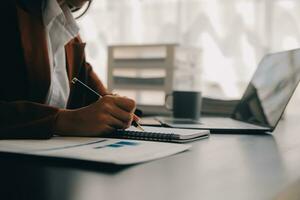 Porträt einer jungen asiatischen Freiberuflerin arbeitet an ihrem Job auf einem Computertablett im modernen Büro. Durchführung von Buchhaltungsanalyseberichten über Immobilieninvestitionsdaten, Konzept von Finanz- und Steuersystemen. foto