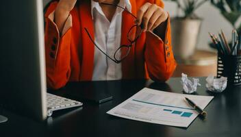 Porträt einer jungen asiatischen Freiberuflerin arbeitet an ihrem Job auf einem Computertablett im modernen Büro. Durchführung von Buchhaltungsanalyseberichten über Immobilieninvestitionsdaten, Konzept von Finanz- und Steuersystemen. foto