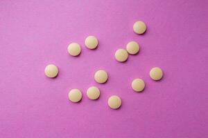 Gelb Tabletten isoliert auf ein Rosa Hintergrund. oben Sicht, eben legen. foto
