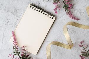 Notizbuch, Band und Blume wird auf weißem Hintergrund platziert foto