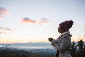 Frau wacht morgens auf, entspannt sich auf dem Berg foto