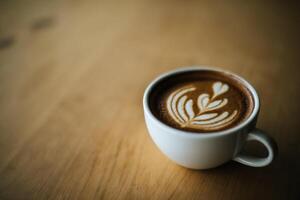 Latte Art in Kaffeetasse auf dem Cafétisch foto