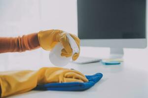 Büro Reinigung Service. Hausmeister Sprühen Schreibtisch. Arbeitsplatz Hygiene foto