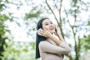 asiatische Frau hört Lieblingsmusik über Kopfhörer. glückliche Zeit und entspannen. foto