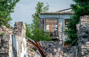 zerstört Häuser im ein verlassen Stadt ohne Menschen im Ukraine foto