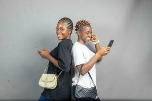 zwei jung afrikanisch Damen Gefühl aufgeregt und glücklich während Anzeigen Inhalt auf ein Telefon zusammen foto
