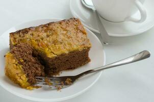 Karamell Erdnuss gekrönt Brownie Kuchen und ein Tasse von Tee foto