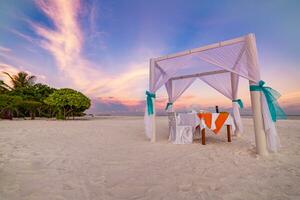 romantisch Abendessen Rahmen auf das Strand beim Sonnenuntergang Himmel. Flitterwochen oder Jahrestag Paar Ziel Essen. Romantik Über Weiß Sand und endlos Meer Sicht. bunt Liebe Sonnenuntergang Himmelslandschaft foto