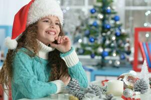 glücklich Mädchen im Santa Hut Sitzung mit Weihnachten Geschenk foto