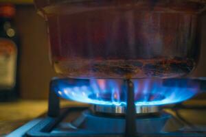 getragen aus Herd Topf oder Kochen schwenken auf ein Verbrennung Gas Kochfeld foto