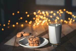 ein Stapel von Kekse und Glas von Milch zum Santa auf hölzern Hintergrund foto