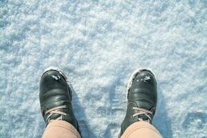 oben Sicht. Füße im Winter Stiefel auf frisch Weiß Schnee. Winter Konzept foto