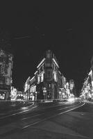 historisch und mittelalterlich die Architektur von Gent während ein dunkel Nacht. Gebäude beleuchtet durch farbig Beleuchtung auf lammerstraat. Flandern Region, Belgien. schwarz und Weiß foto