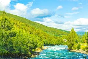 Türkisfarbenes Schmelzwasser fließt im Fluss durch die Gebirgslandschaft Norwegens