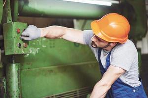 Industriearbeiter, der mit Drehmaschine in der metallverarbeitenden Industrie arbeitet foto