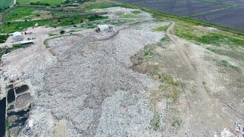 Müll Dump mit haufen von Müll und Behandlung Einrichtungen. Deponie von Müll draußen das Dorf foto