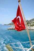 Truthahn Flagge beim das Stern von ein Vergnügen Yacht. Aussicht von Mittelmeer Küste foto