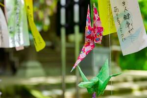 ein Papier Kran schwankend im das Wind beim das traditionell Straße schließen oben foto