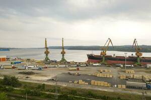 Antenne Aussicht von Drohne von Wird geladen das Ladung Schiff. Arbeit im Hafen. foto