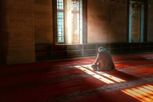islamisch Foto. Muslim Mann beten im das Moschee. Sonnenlicht Strahlen und Dunst foto