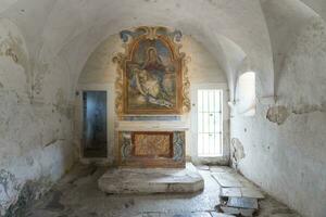 L'Aquila, Italien-August 12, 2021-Ruinen von das Einsiedelei von das heilig Geist ein uralt Kirche gegraben in ein Cliff mit ein gut erhalten Fresko, Altar und Einsiedler Zellen. foto