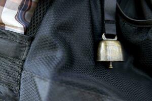 ein Rucksack mit Bär Glocke beim das Grün Wald im Herbst Nahansicht foto