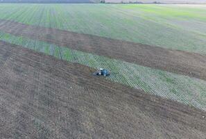 oben Aussicht von das Traktor Das pflüge das Feld. Festplatten das Boden. Boden Anbau nach Ernte foto