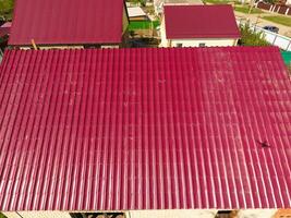 ein Haus mit ein rot Dach gemacht von gewellt Metall Blätter. Dach von gewellt Metall Profil. Metall Fliesen. foto