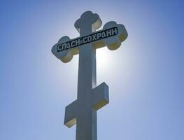 orthodox Kreuz gegen das Blau Himmel und das Sonne. Kreuz im das ba foto