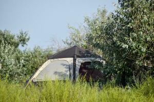 Tourist Zelt unter ein Baum. Tourist Camping. Multizelt foto