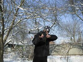 Mann mit ein Luft Gewehr im ein Winter Park. foto