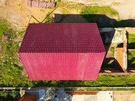 ein Haus mit ein rot Dach gemacht von gewellt Metall Blätter. Dach von gewellt Metall Profil. Metall Fliesen. foto