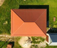 Haus mit ein Orange Dach gemacht von Metall, oben Sicht. metallisch Profil gemalt gewellt auf das Dach. foto