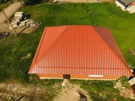 Haus mit ein Orange Dach gemacht von Metall, oben Sicht. metallisch Profil gemalt gewellt auf das Dach. foto